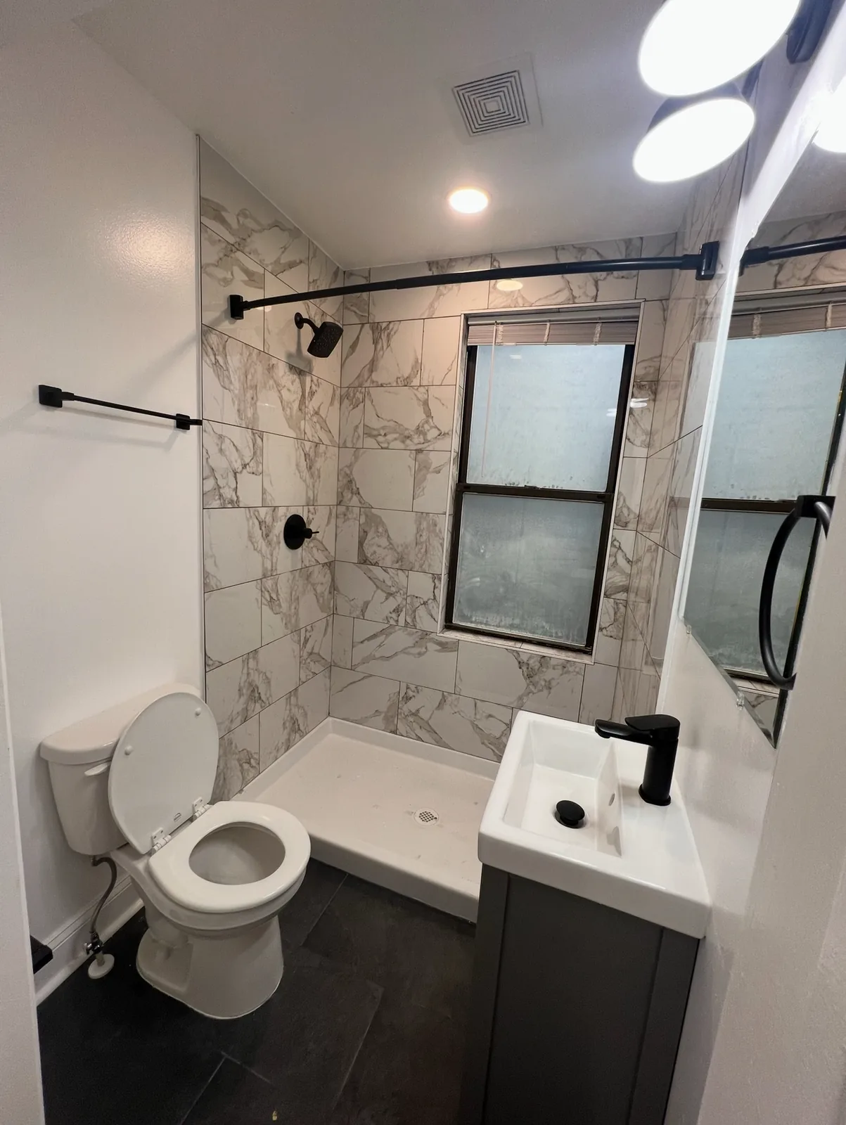 Compact bathroom with a tiled shower and new fixtures