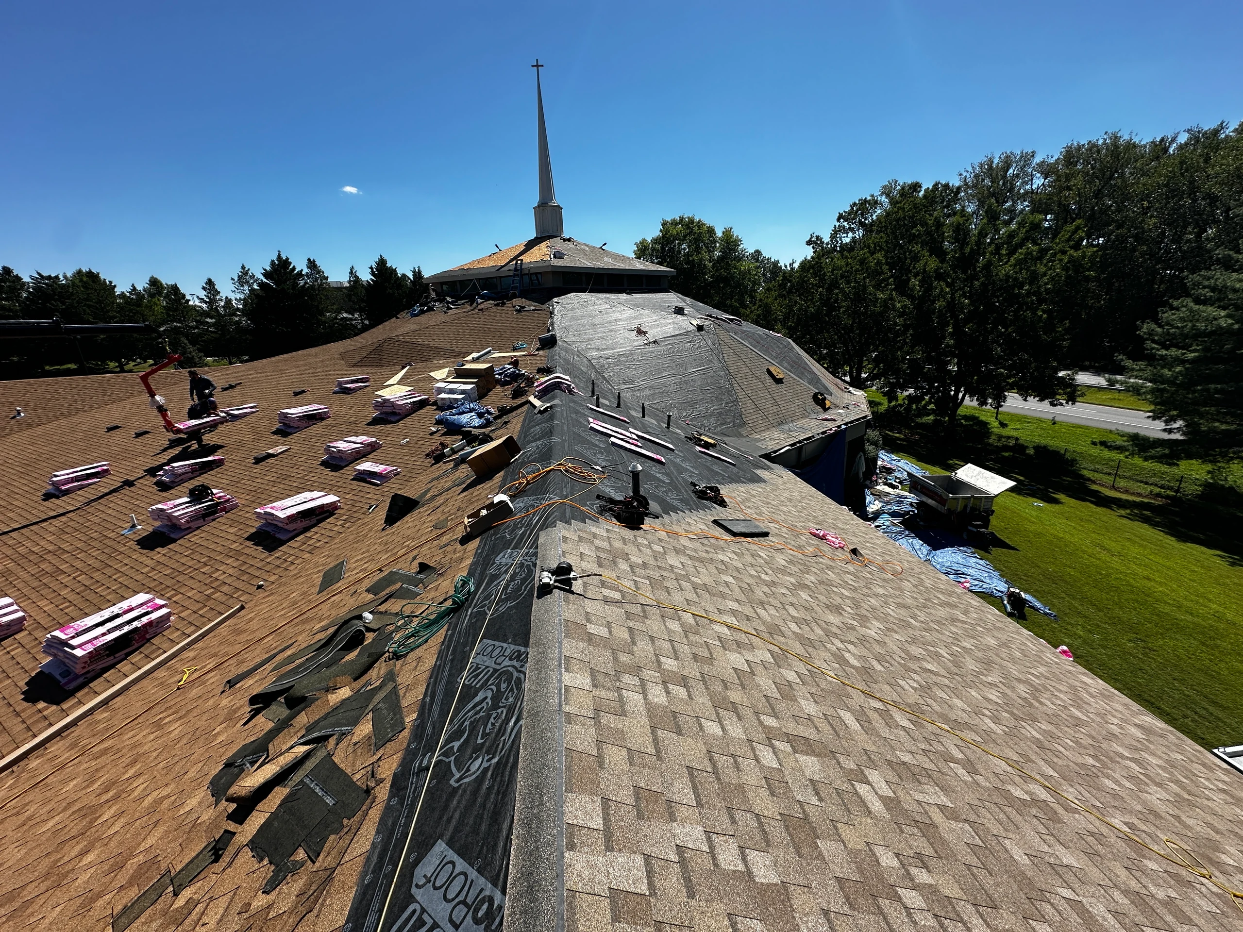 Church roof replacement in progress with shingles and underlayment