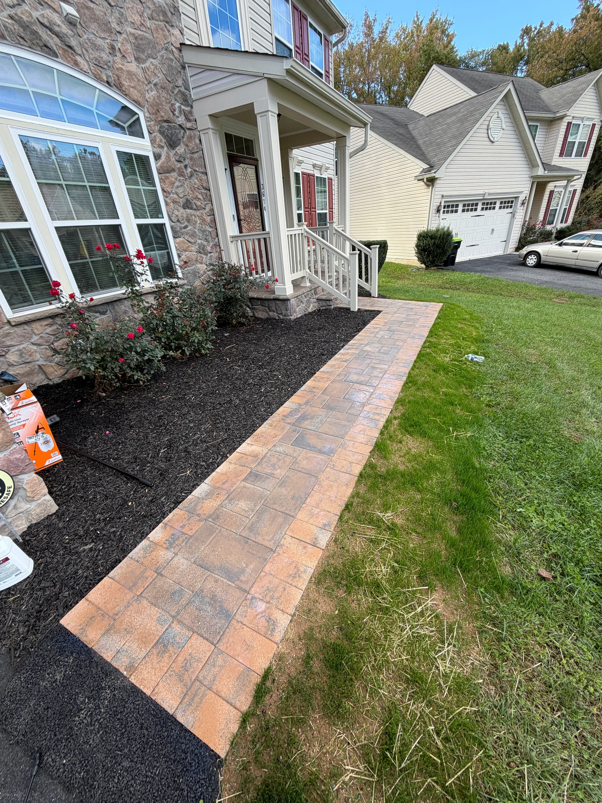 Paver walkway leading to the front porch and landscaped beds