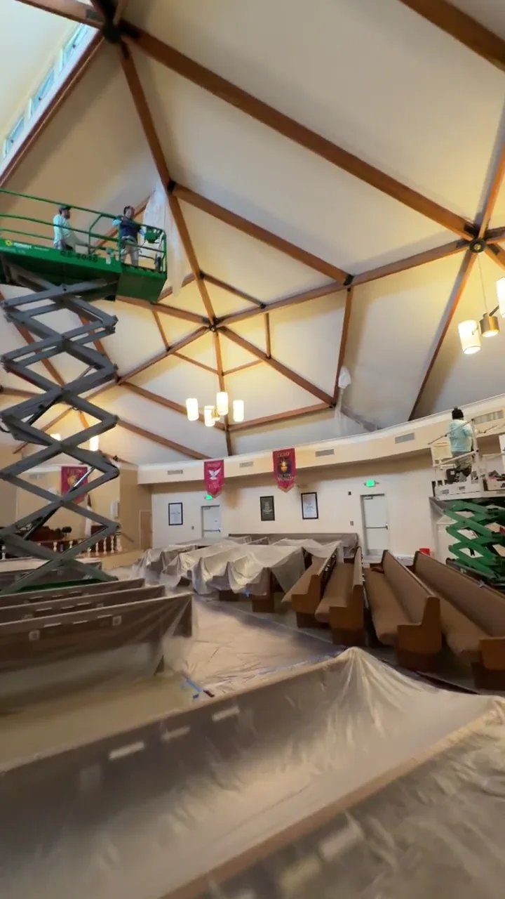 Church interior renovation in progress beneath exposed timber beams